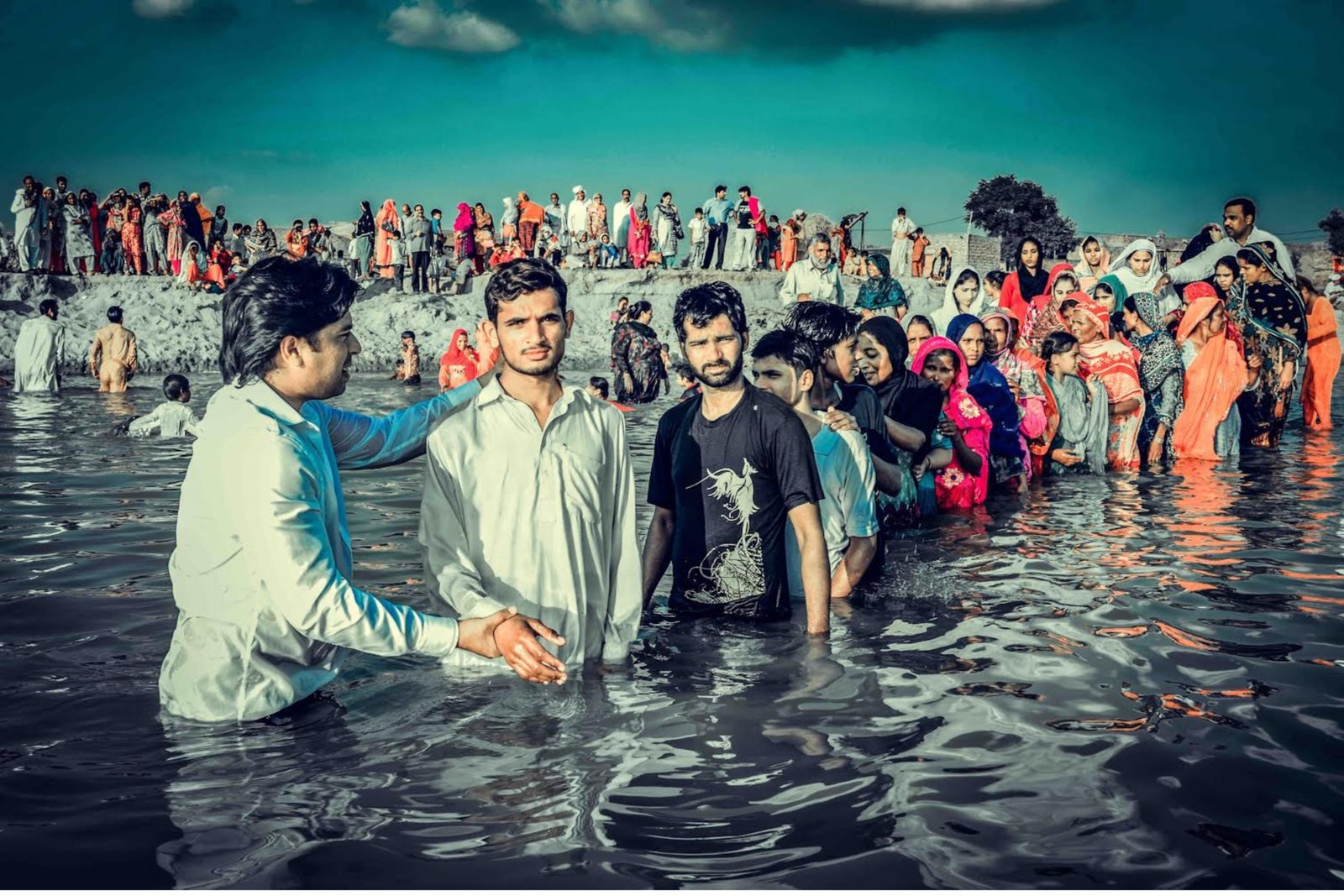 New believers being baptised in a river in Pakistan after a gospel crusade
