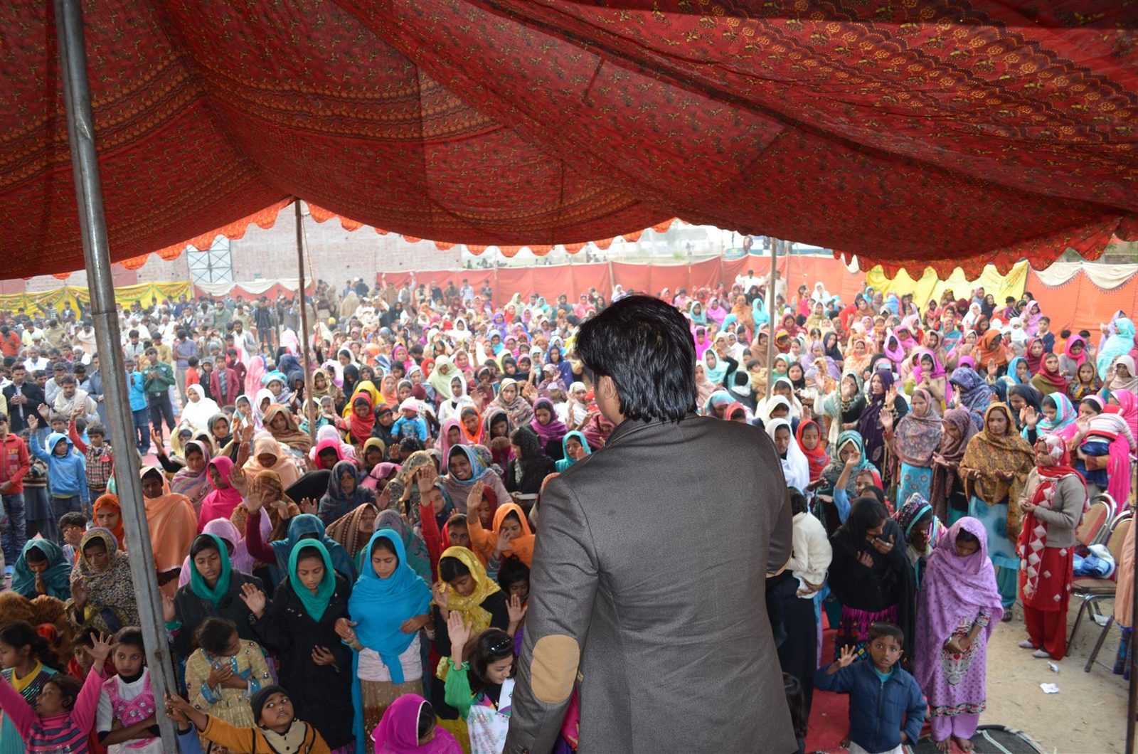 Rev. Dr. Naeem Nasir preaching to thousands under a crusade tent in Pakistan where free Urdu Bibles are distributed
