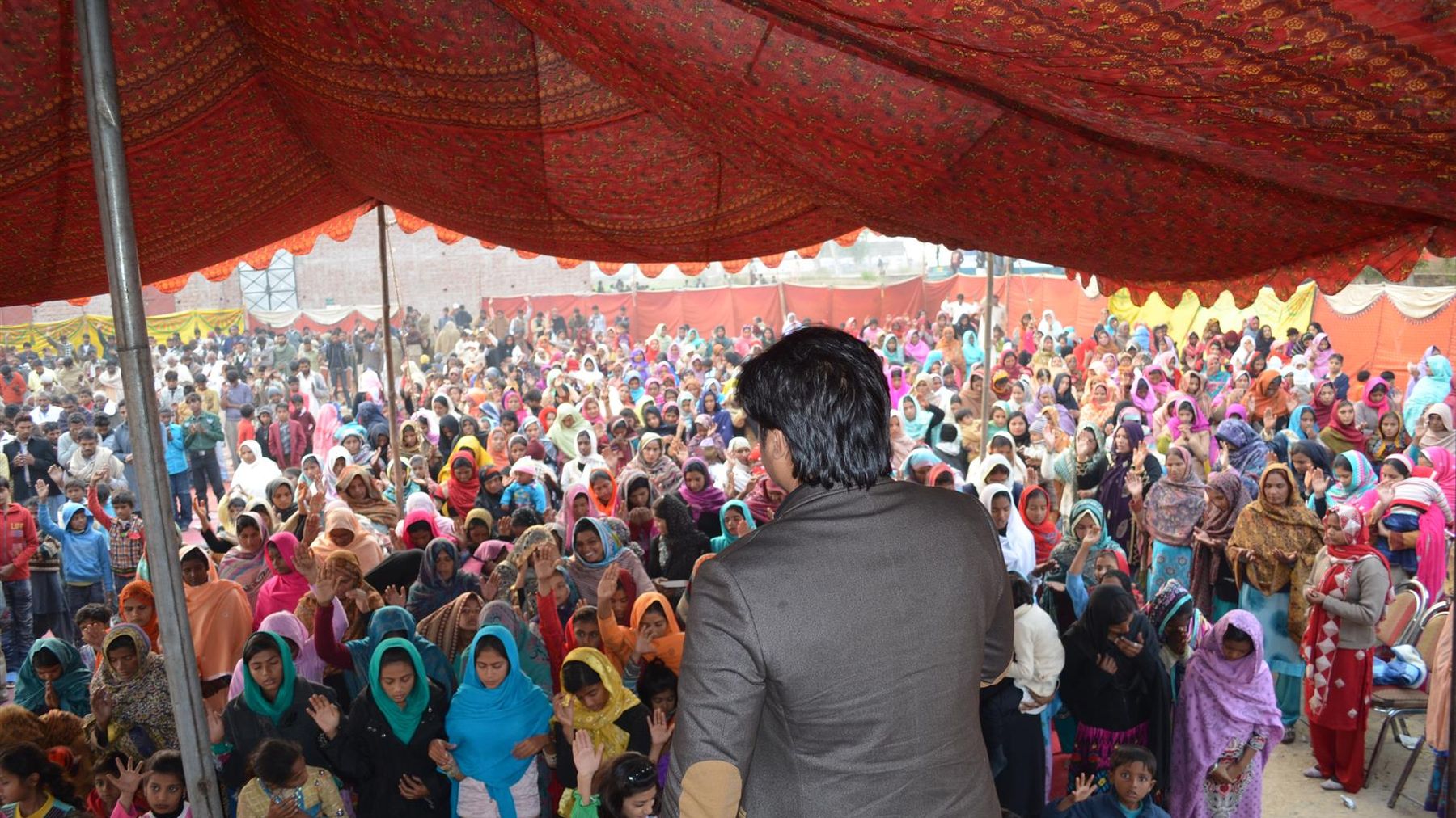 Rev. Dr. Naeem Nasir preaching to thousands under a crusade tent in Pakistan