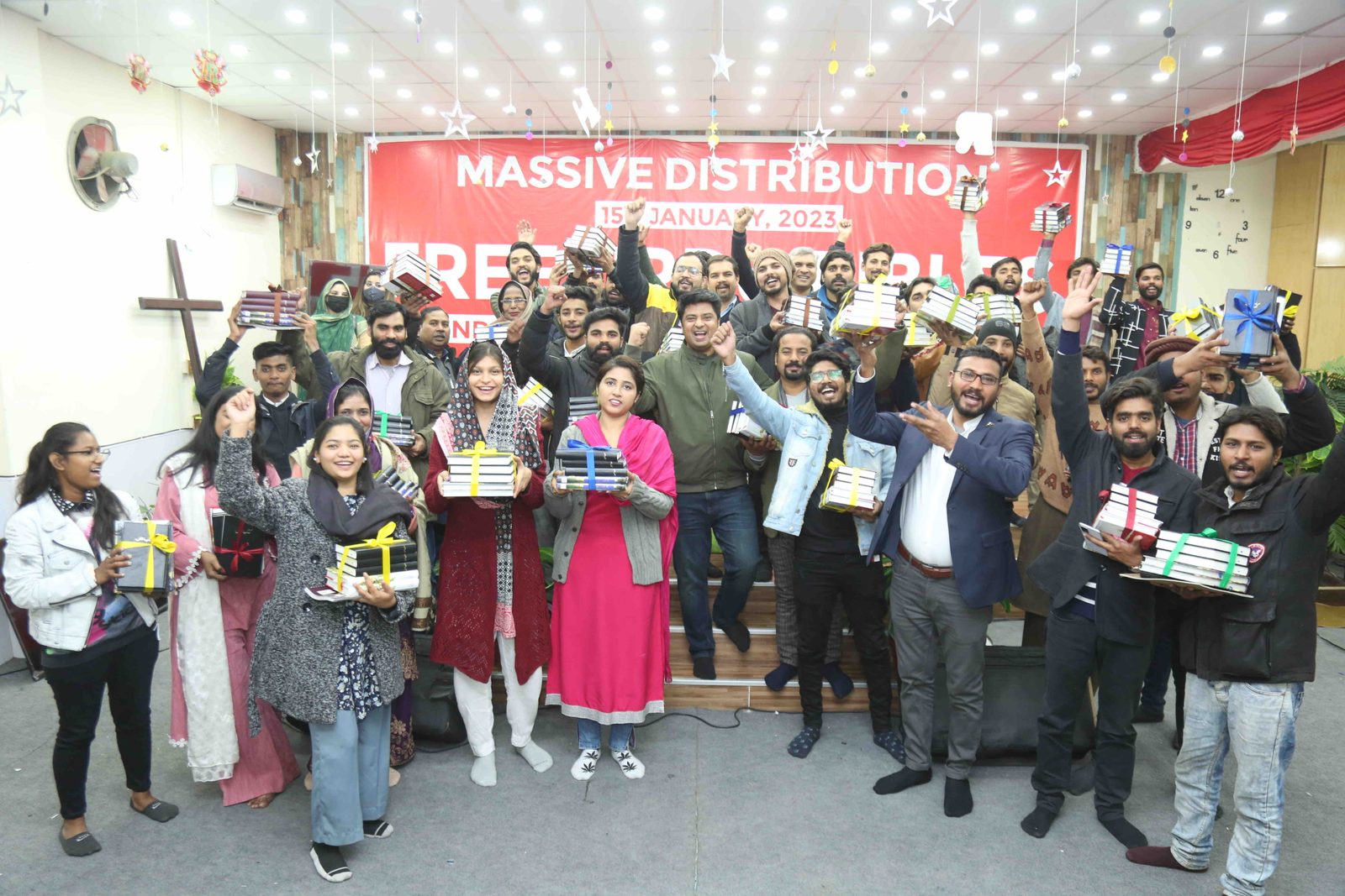 A mass free Urdu Bible distribution event in Lahore, Pakistan, with believers holding up Bibles