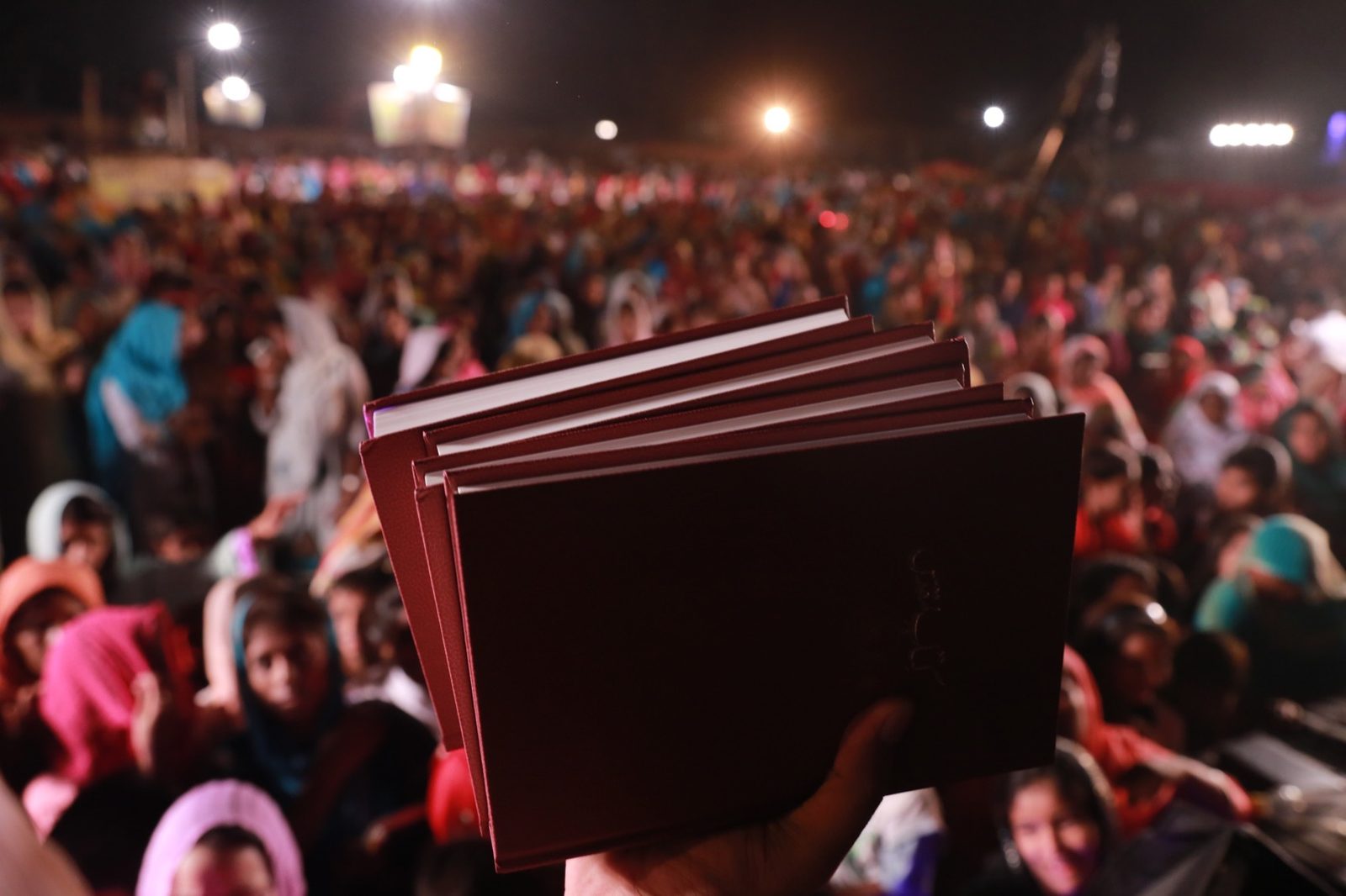 A new Urdu Bible held high above a crowd at a crusade in Pakistan